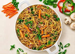 Vegetable Hakka noodles with carrots and spring onions served at an Indian restaurant.